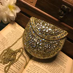 Elevate your style with the Mini Kundan Clutch, featuring exquisite crystal inlays and a regal gold clasp, blending tradition with modern luxury effortlessly.